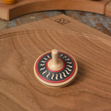 Mader Kreiselmanufaktur arabesk wooden finger spinning top placed on an oak spinning plate in the Babipur playroom.