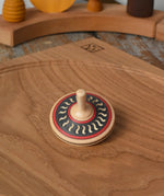 Mader Kreiselmanufaktur arabesk wooden finger spinning top placed on an oak spinning plate in the Babipur playroom.