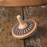 Mader Kreiselmanufaktur arabesk wooden finger spinning top placed on a wooden desk in the Babipur playroom.