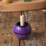Mader Kreiselmanufaktur round ash turn over spinning top toy placed on a wooden desk in the Babipur playroom.