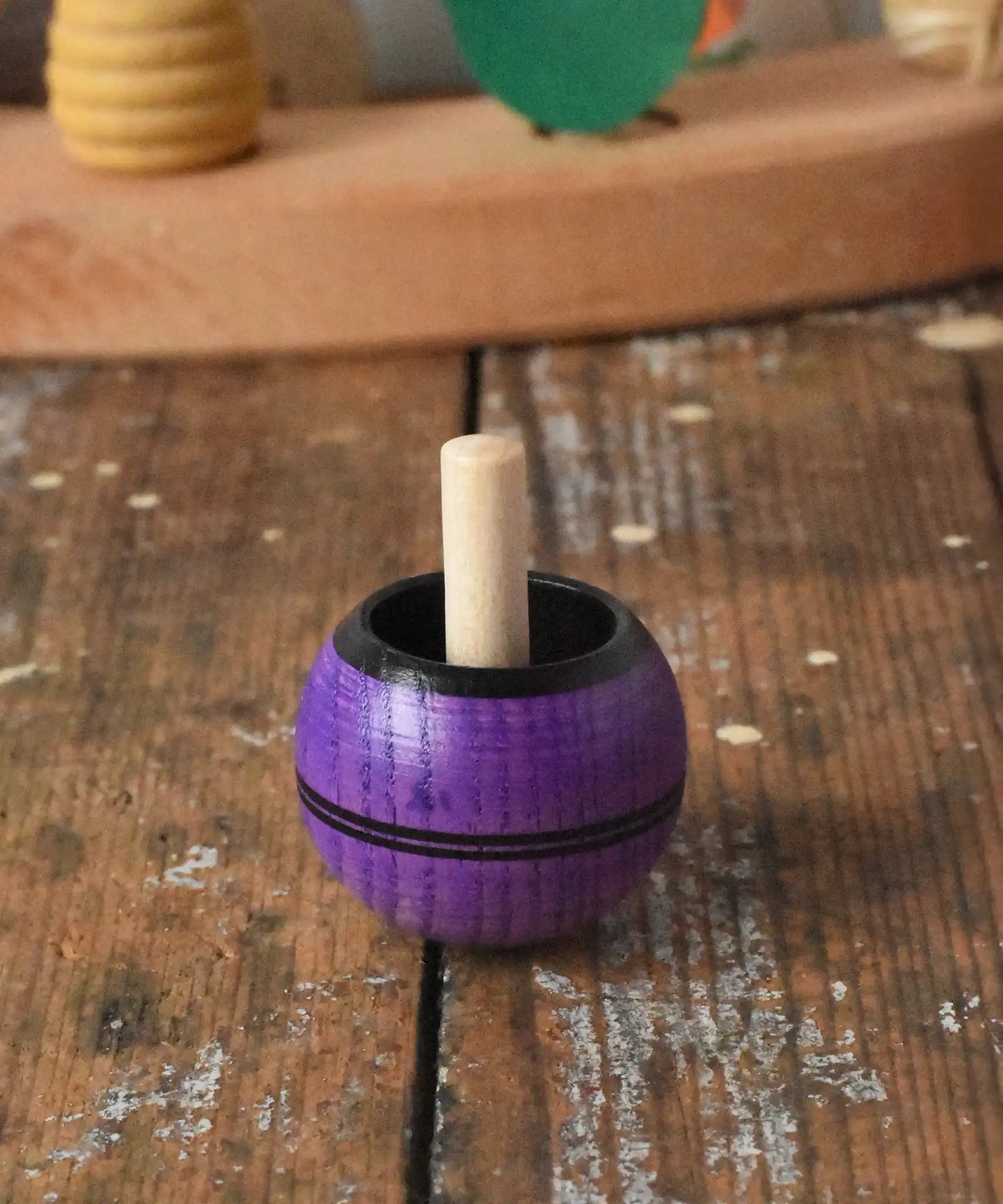 Mader Kreiselmanufaktur round ash turn over spinning top toy placed on a wooden desk in the Babipur playroom.