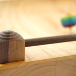 Close up of the walnut frame around the edge of a Mader handmade ash wood Manege spinning plate