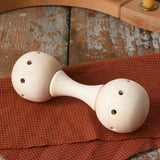 Mader Kreiselmanufaktur traditional wooden baby rattle placed on a cloth on a wooden surface in the Babipur playroom. 