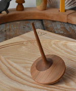 Mader ballerina wooden spinning top  placed on an ash spinning plate in the Babipur playroom. 