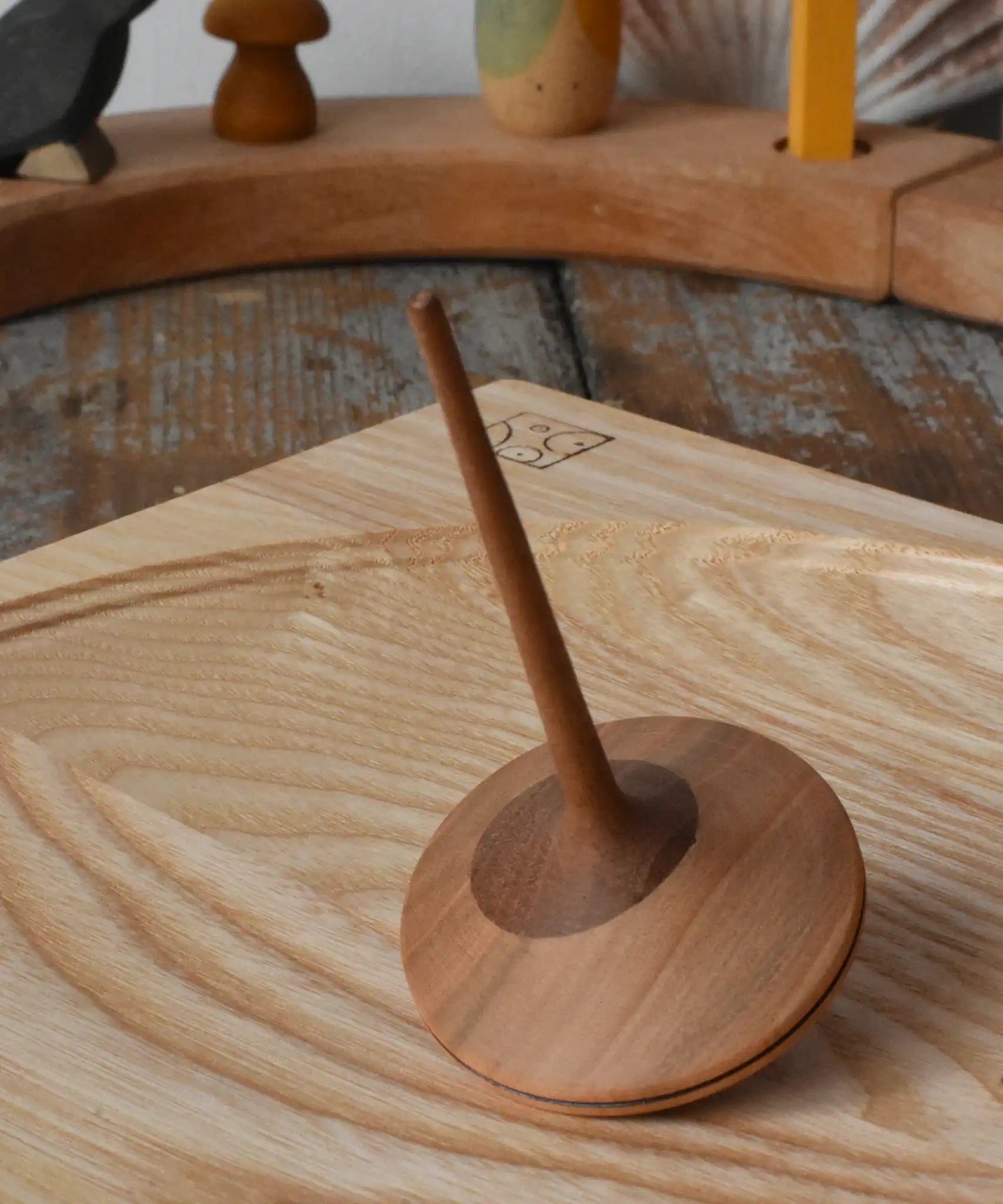Mader ballerina wooden spinning top  placed on an ash spinning plate in the Babipur playroom. 