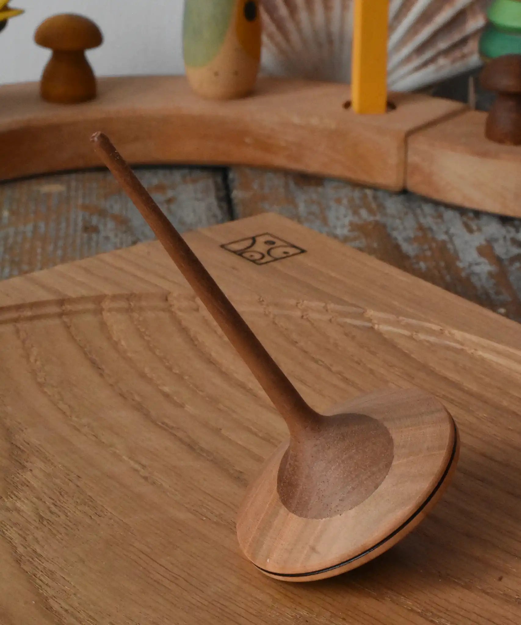 Mader ballerina wooden spinning top placed on an oak spinning plate in the Babipur playroom. 