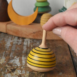 Mader bee spinning top placed on a wooden desk in the Babipur playroom. 