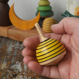 Mader bee spinning top shown in an adult's hand.
