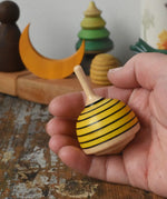 Mader bee spinning top shown in an adult's hand.