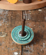 Blue Mader Kreiselmanufaktur bonbon wooden spinning top placed on a wooden desk in the Babipur playroom.