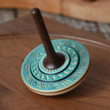 Mader Kreiselmanufaktur bonbon wooden spinning top in blue placed on a walnut wood spinning plate in the Babipur playroom.