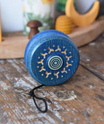 Mader burlesk wooden yoyo in blue placed on a wooden surface in the Babipur playroom. 
