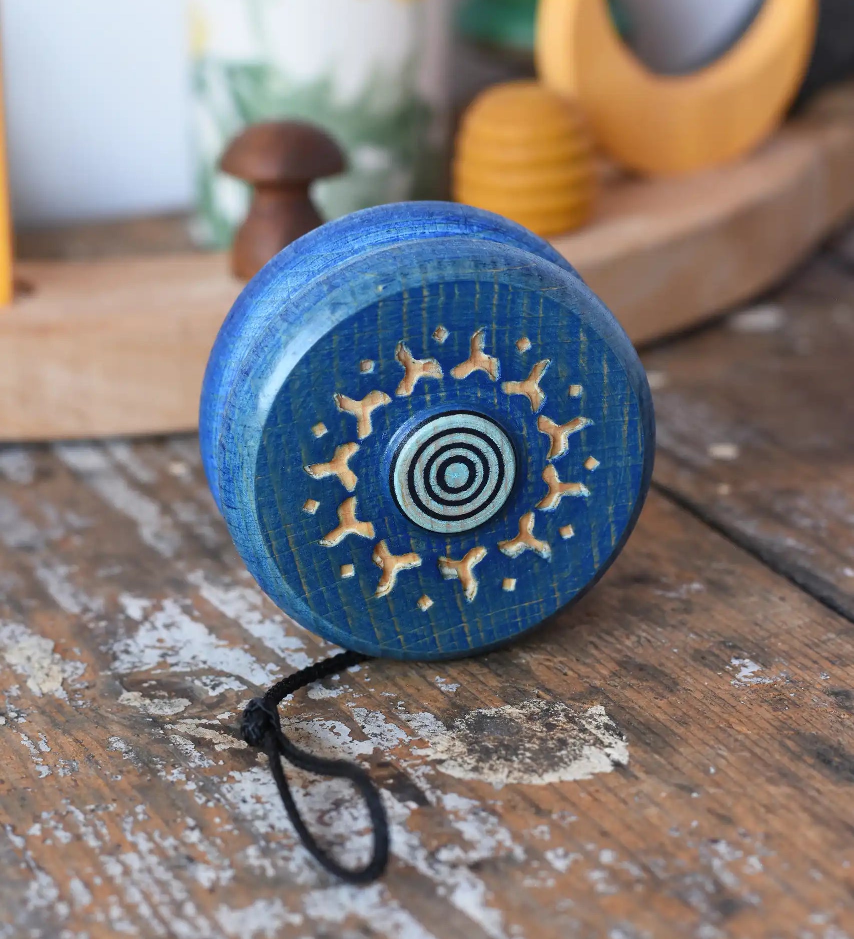 Mader burlesk wooden yoyo in blue placed on a wooden surface in the Babipur playroom. 