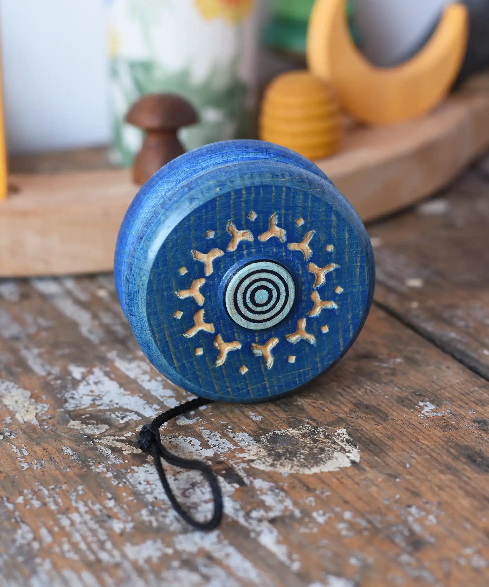 Mader burlesk wooden yoyo in blue placed on a wooden surface in the Babipur playroom. 