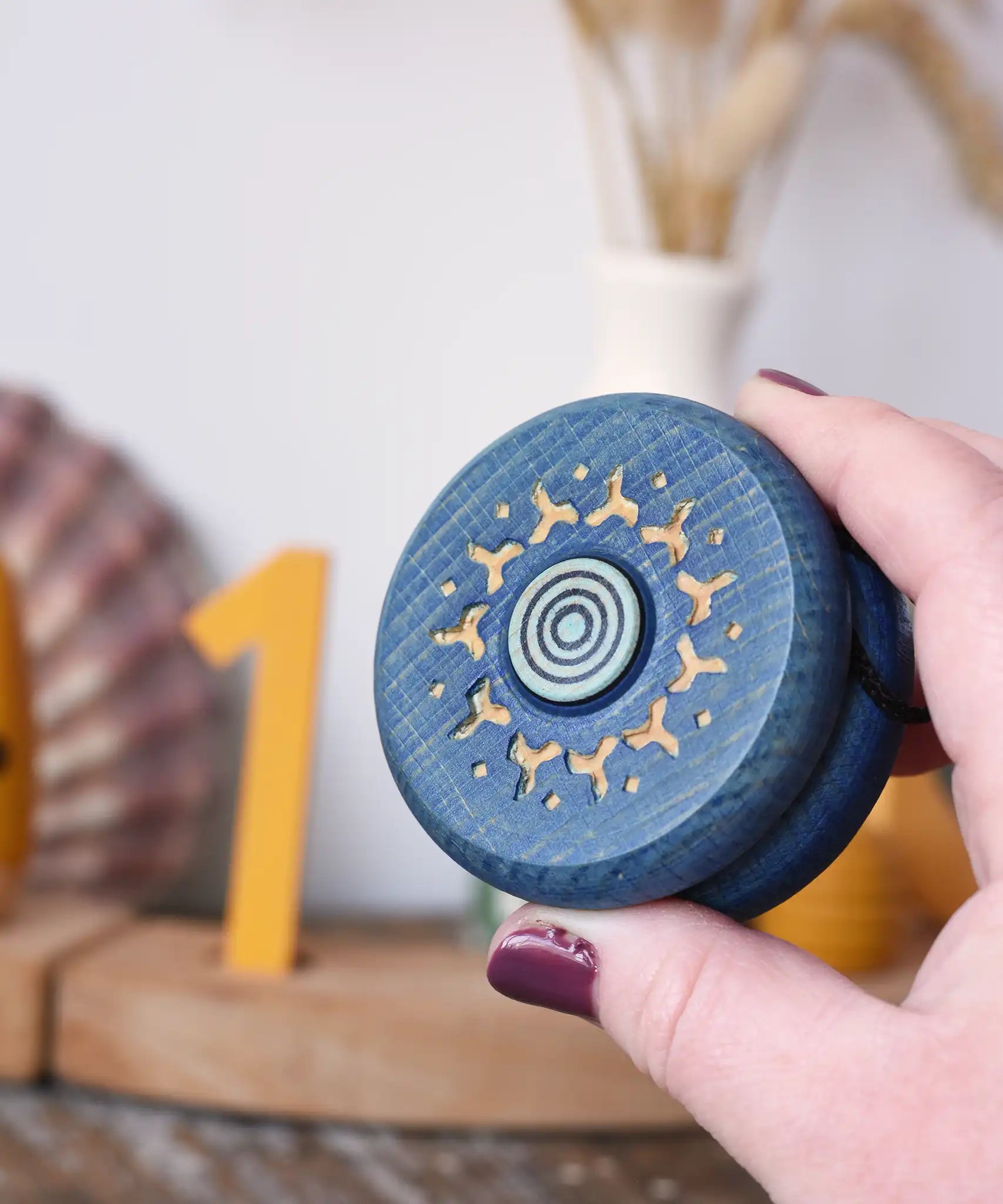 Mader burlesk wooden yoyo in blue in an adult hand. 