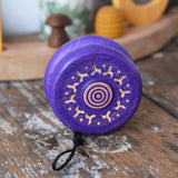 Mader burlesk wooden yoyo in purple placed on a wooden surface in the Babipur playroom. 