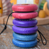 Stack of three Mader burlesk wooden yoyos placed on a wooden surface in the Babipur playroom.