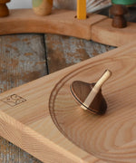 Mader Charlie finger spinning top placed on an ash spinning plate in the Babipur playroom.