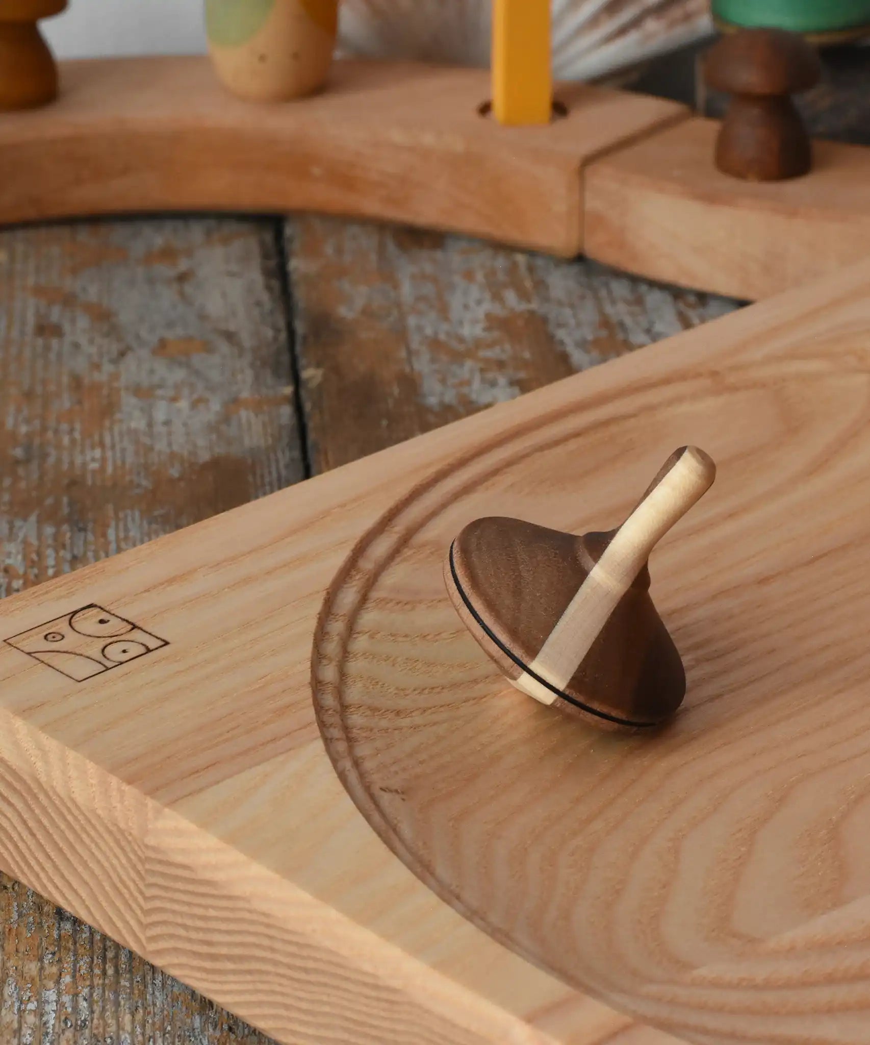 Mader Charlie finger spinning top placed on an ash spinning plate in the Babipur playroom.