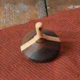 Mader Charlie finger spinning top placed on a piece of cloth on a desk in the Babipur playroom.