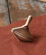 Mader Charlie finger spinning top placed on a piece of cloth on a desk in the Babipur playroom.