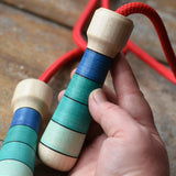 Mader Skipping Rope with Blue Handles, one handle shown in an adult's hand.