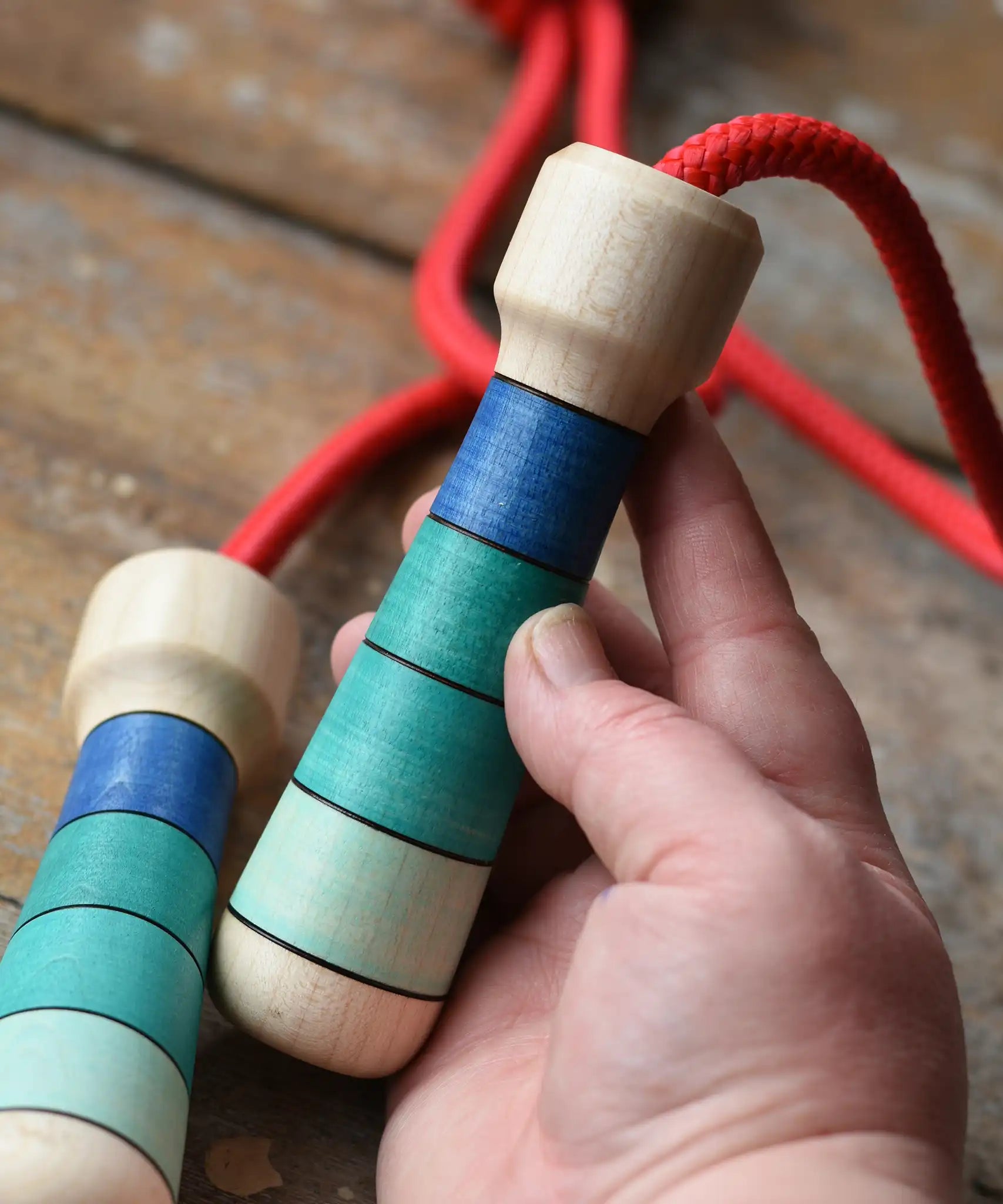 Mader Skipping Rope with Blue Handles, one handle shown in an adult's hand.