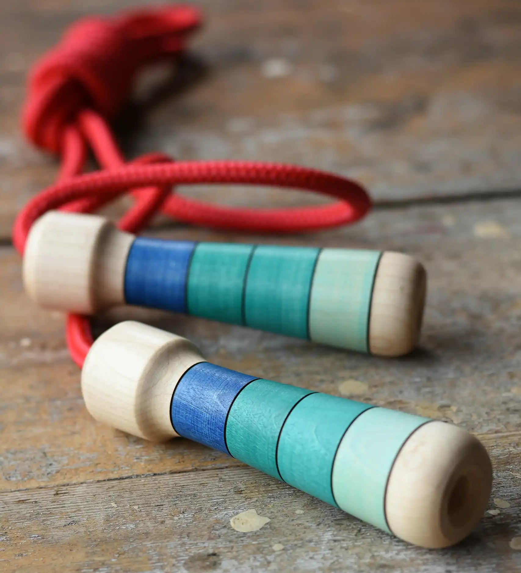 Mader Skipping Rope with Blue Handles placed on a wooden board in the Babipur playroom.