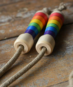 Mader Kreiselmanufaktur Children's Skipping Rope Rainbow Handles placed on a wooden surface in the Babipur playroom.