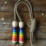 Mader Kreiselmanufaktur Children's Skipping Rope Rainbow Handles placed on a wooden surface in the Babipur playroom.
