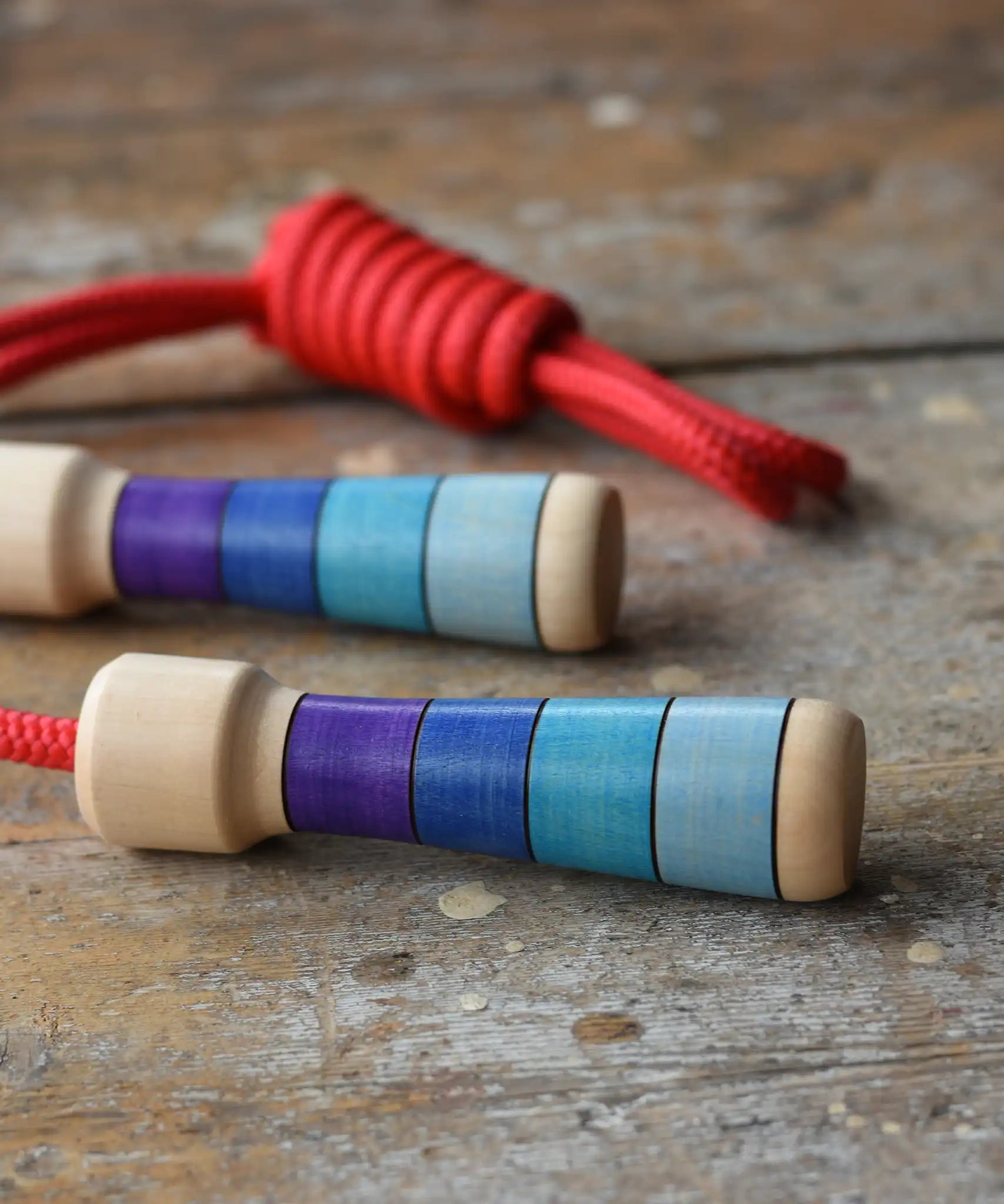 Mader Kreiselmanufaktur Children's Skipping Rope with Purple Handles placed on a wooden surface in the Babipur playroom. 