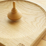 Mader kids classic wooden spinning top toy on a wooden Mader spinning top plate