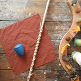 Mader Kreiselmanufaktur Classic Whip Wooden Spinning Top in blue shown placed on a wooden desk in the Babipur playroom.