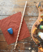 Mader Kreiselmanufaktur Classic Whip Wooden Spinning Top in blue shown placed on a wooden desk in the Babipur playroom.