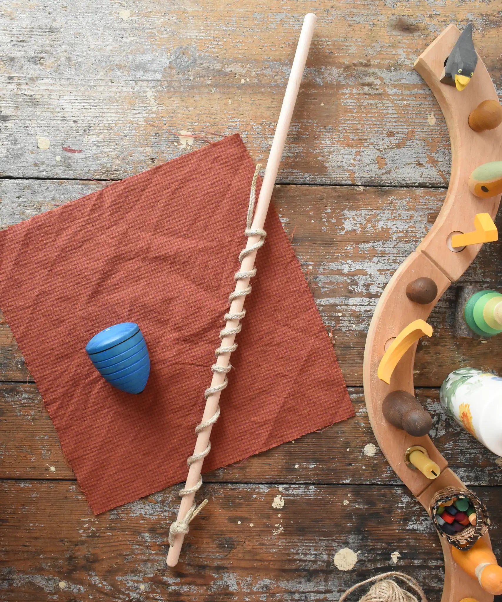 Mader Kreiselmanufaktur Classic Whip Wooden Spinning Top in blue shown placed on a wooden desk in the Babipur playroom.