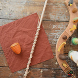 Mader Kreiselmanufaktur Classic Whip Wooden Spinning Top in orange shown placed on a wooden desk in the Babipur playroom.