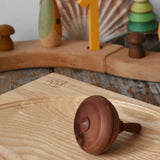 Mader classic spinning top placed on an ash spinning plate on it's side in the Babipur playroom.