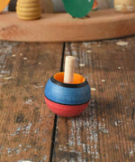 Mader Kreiselmanufaktur confetti turn-over wooden spinning top placed on a wooden desk in the Babipur playroom. 