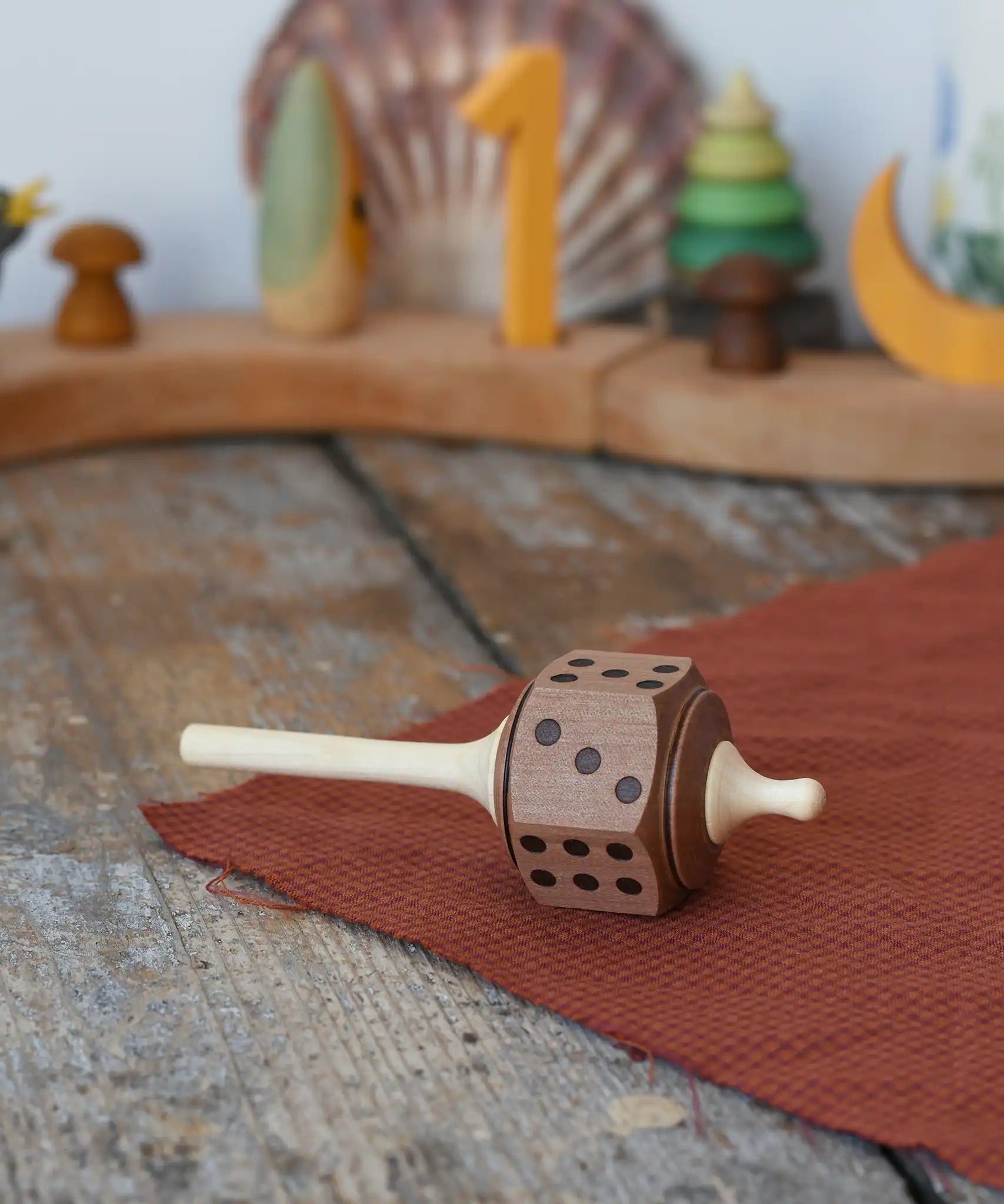 Mader Dice Spinning Top placed on a wooen desk in the Babipur playroom.