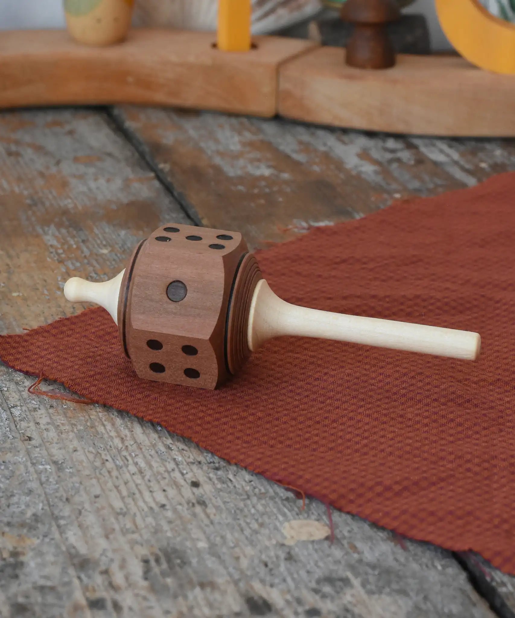 Mader Dice Spinning Topplaced on a wooden desk in the Babipur playroom.