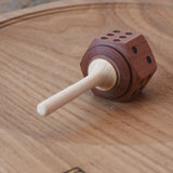 Mader Dice Spinning Top placed on an oak spinning plate in the Babipur playroom.