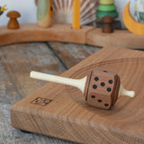 Mader Dice Spinning Top placed on an oak spinning plate in the Babipur playroom.