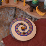 Mader Disc spinning Top Geometric blurred in motion, spinning on a wooden desk in the Babipur playroom.