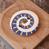 Mader Disc spinning Top Geometric placed on an oak spinning plate on a desk in the Babipur playroom.
