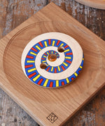 Mader Disc spinning Top Geometric placed on an oak spinning plate on a desk in the Babipur playroom.