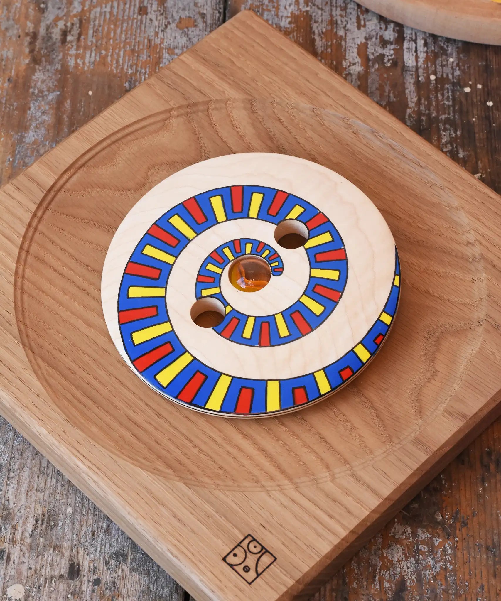 Mader Disc spinning Top Geometric placed on an oak spinning plate on a desk in the Babipur playroom.