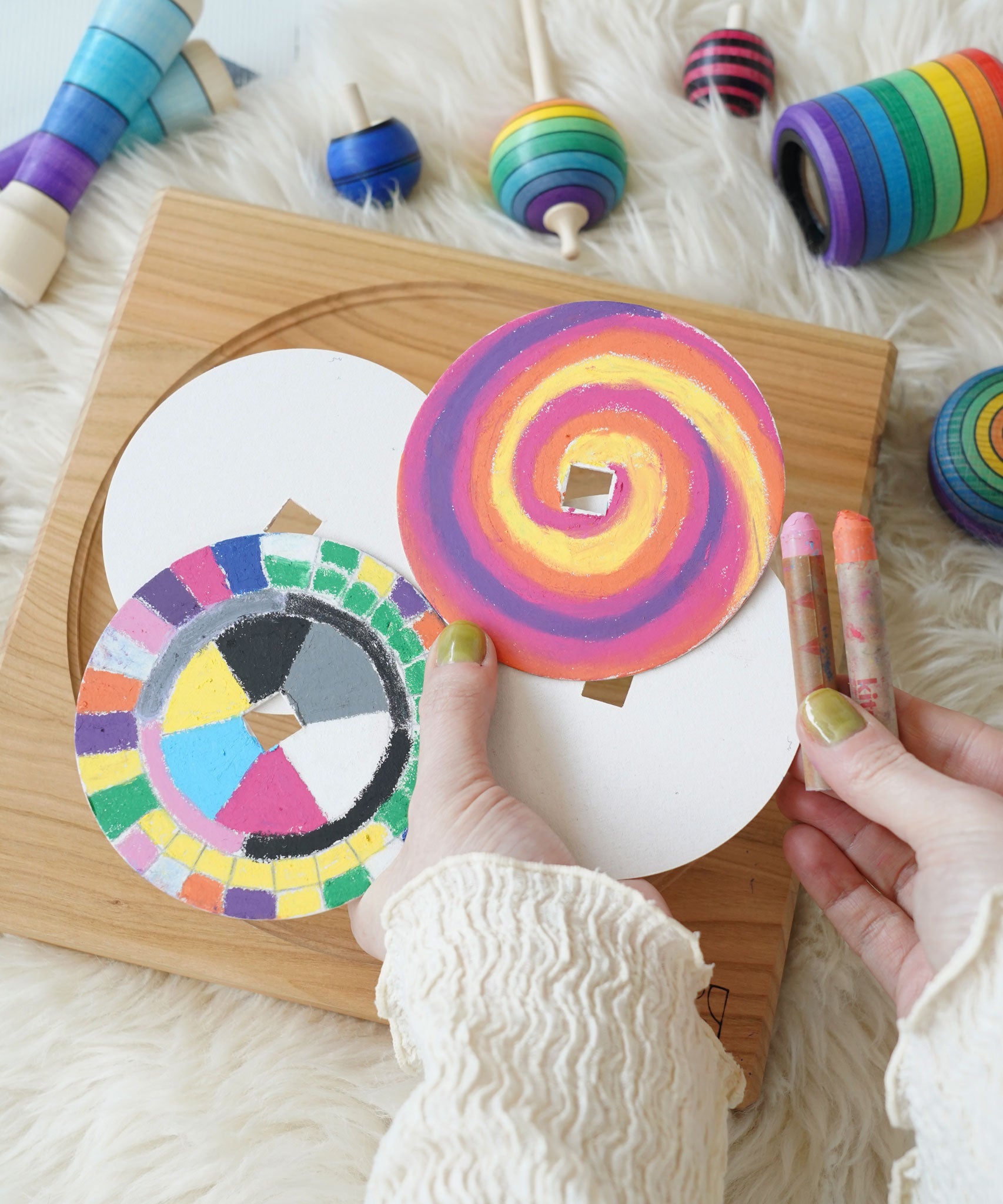 Four replacement discs for 'So And So' set. Two have been left blank and two have been coloured using Kitpas crayons. One has a swirl design and the other has a square colour block design. 