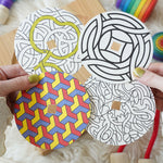 The four cardboard discs included in the Mader So and So wooden spinning top set. 