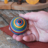 Bottom of the Mader dragon egg spinning top in an adult's hand.
