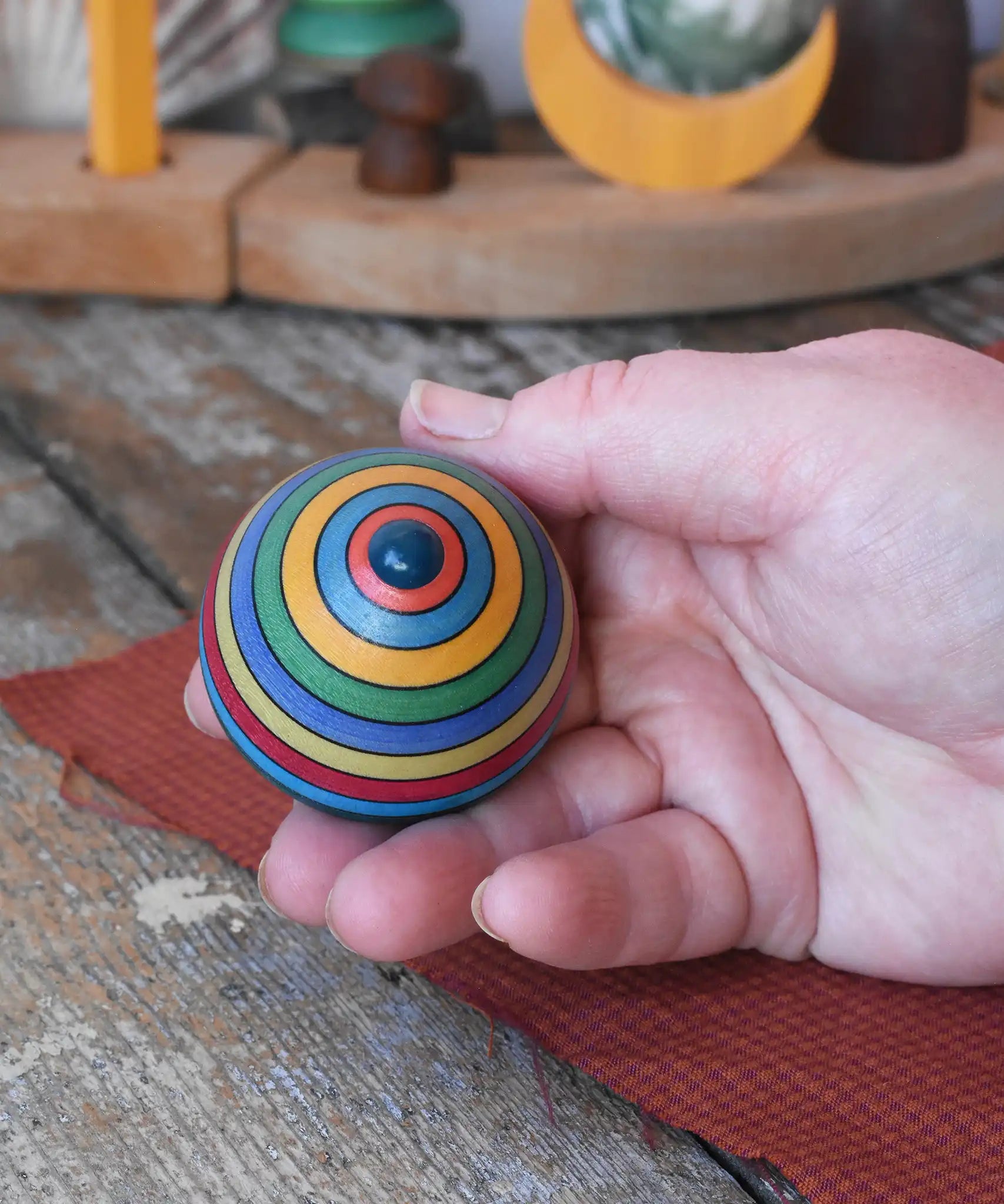 Bottom of the Mader dragon egg spinning top in an adult's hand.